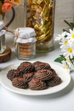 Yuvarlak kenarlı ev yapımı çikolatalı kurabiyeler ve ortasında çikolata düğmesi. Festival tatlı temaları için mükemmel..