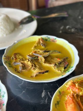 Çiçek kaselerinde servis edilen pirinç, yumurta, zerdeçal körisi ve fasulye filizi gibi otantik Malezya usulü yemekler..