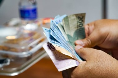 Elleri sayan Endonezya Rupiah notları, finans, ekonomi, seyahat ve günlük yaşam kavramı.