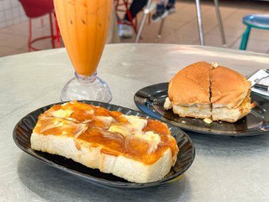 Geleneksel Malezya kahvaltısı çörek, tost ve buzlu süt çayı..
