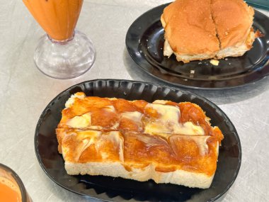 Geleneksel Malezya kahvaltısı çörek, tost ve buzlu süt çayı..