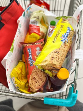 Johor, Malezya, 10 Şubat 2026: Market arabasında çeşitli bakkaliye ve paketlenmiş gıda eşyalarıyla dolu alışveriş poşetleri.