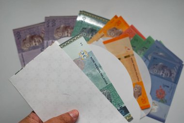 Zarfların içinde birden fazla değer içeren renkli Malezya Halkaları banknotları.