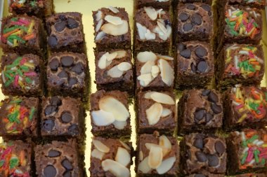 Badem, cips ve serpiştirilmiş nemli çikolatalı kek kareleri seçici bir odak noktası. Kapat..