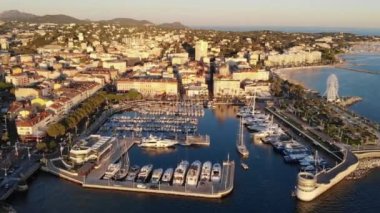 Gün batımında gökyüzünden çekilen Aziz Raphael. Altın saat. Deniz manzarası, yatları, evleri, kiliseleri ve plajları olan liman. Cote d 'Azur, Fransa 4K 60fps