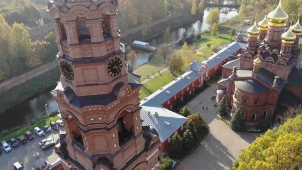 秋天的晴天 空中俯瞰着河畔的钟楼和红砖大教堂 Gethsemane Chernigov Skete Sergiyev Posad Russia 视频剪辑