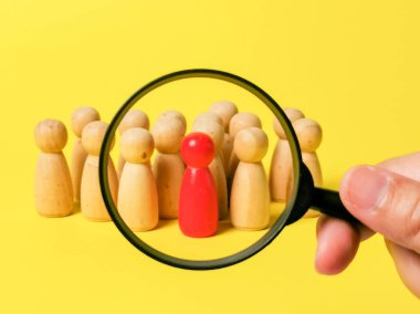 Büyüteç grup arasındaki kırmızı rakamı vurguluyor, liderlik ve benzersizliğe odaklanıyor.