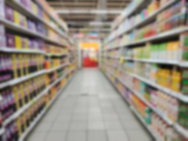 Modern bir perakende ortamda uzun rafların bulanık görüntüsü.