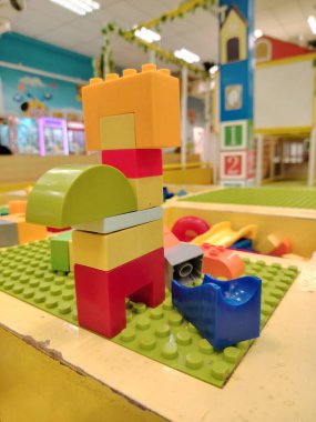 Uzun, renkli bina bloğu kulesi kapalı oyun alanı arka planına sahip özel bir oyun masası üzerine inşa edilmiş..