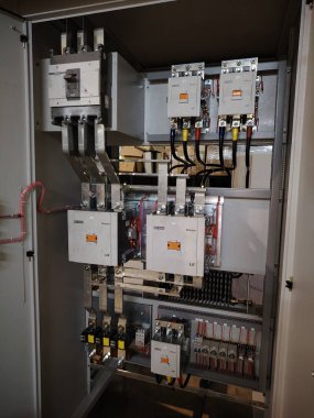 Devre kesici ve konteynırları olan endüstriyel güç kontrol paneli.