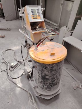 Bir imalat atölyesinde elektrostatik toz spreyleme sistemi.