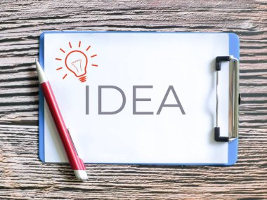Yaratıcılık ve yeniliği temsil eden bir pano üzerindeki ampul sembolü ve IDEA metni.