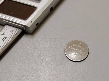 Boyut karşılaştırması için bir dijital ölçüm kalibre ölçekli Lityum Hücre pili.
