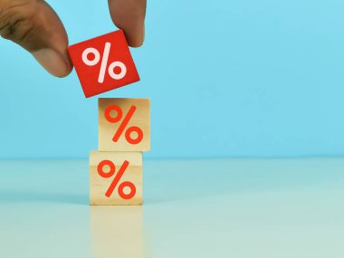 Bir kişinin eli, kredi veya satış yüzdesini belirlemek için son bloğu yerleştirir.