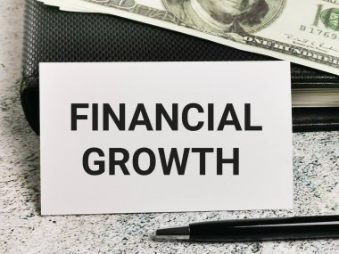 Servet artışını vurgulayan bir konsept kart, nakit ve kalemle birlikte bir defter üzerine kurulmuş..