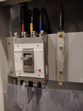 Bir dağıtım paneli içinde büyük bir endüstriyel devre kesici ve bakır çubukların profesyonel kurulumu.