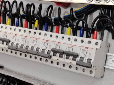 Organize devre kesiciler ve kablolar içeren profesyonel endüstriyel kontrol paneli.