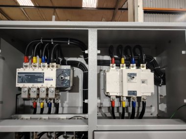 Otomatik aktarım anahtarları ve organize kabloları olan profesyonel bir güç yönetimi kabinesinin iç görünümü.