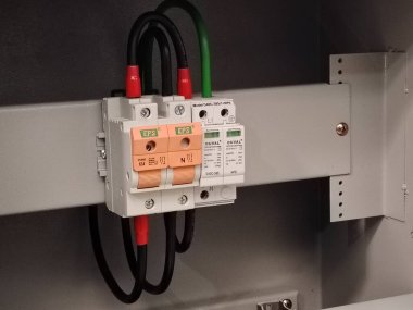 Endüstriyel elektrik bileşenlerine yakın çekim, dalgalanma aygıtı ve topraklama bakır bar bağlantıları dahil.