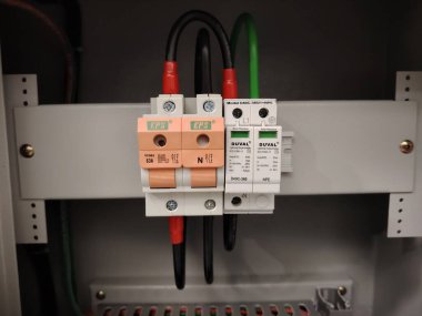 Etiketli devre kesicileri ve dalgalanma cihazı olan bir sanayi santral dolabının içi..