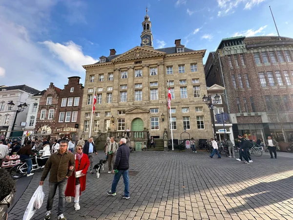 Den Bosch 'un tarihi belediye binası önünde canlı kalabalık ve klasik Hollanda mimarisi ile pazar kare hayatı.