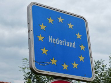 Hollanda sınırını gösteren 13 sarı yıldızlı mavi kare yol tabelası.