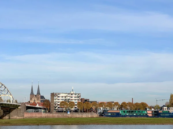 Bergkerk, IJssel nehri ve aydınlık bir sonbahar gününde köprü ile Deventer şehir merkezinin görüntüsü.