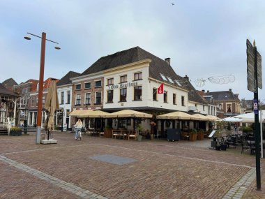 Hollanda 'nın Hanseatik kenti Elburg' daki Olde Regthuys 'ta, bulutlu bir kış gününde teras kafeleri bulunan tarihi kasaba meydanı. Elburg, Hollanda, Aralık 05, 2025