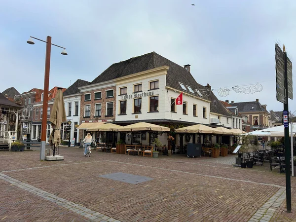 Hollanda 'nın Hanseatik kenti Elburg' daki Olde Regthuys 'ta, bulutlu bir kış gününde teras kafeleri bulunan tarihi kasaba meydanı. Elburg, Hollanda, Aralık 05, 2025