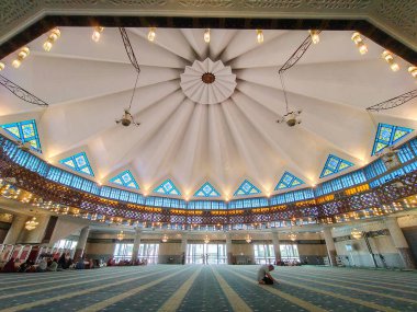 Kuala Lumpur, Malezya 6 Mart 2026: Simetrik kubbeli tavan ve Ulusal Cami namaz salonunun tarihi yapısının içindeki vitray pencereler.