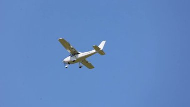Küçük Beyaz Yüksek Kanatlı Spor Uçağı Tek Ön Pervaneli Açık Mavi Bir Yaz Gökyüzüne Karşı Uçuyor
