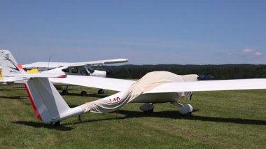 Küçük Motorize ve Planör Uçakları Bir Mown Çimen Havaalanı 'nda Sıralanmış, Bir Havacılık Sergisi sırasında Açık Şekilleri ve Uçuşa Hazır Ayarlamalarıyla