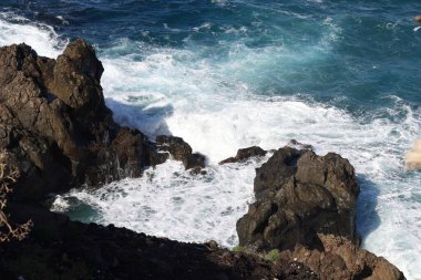 Güçlü okyanus dalgaları, San Juan de la Rambla yakınlarındaki Tenerifes 'in kuzey kıyısındaki volkanik kayalara çarpıyor.