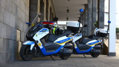 Puerto de la Cruz, Tenerife, 01152026 Üstü kapalı bir taş geçidin altına park edilmiş iki polis motosikleti, kasklar, sirenler ve iletişim birimleri, Kanarya Adaları 'ndaki yerel devriyeleri vurguluyorlar..