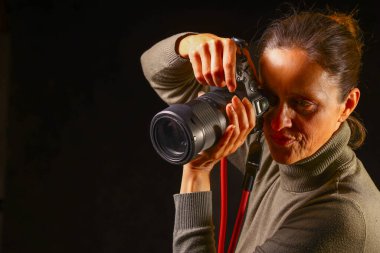 Photographer aiming a professional camera upward, illustrating technique, grip, and equipment handling essential for capturing elevated or dynamic angles