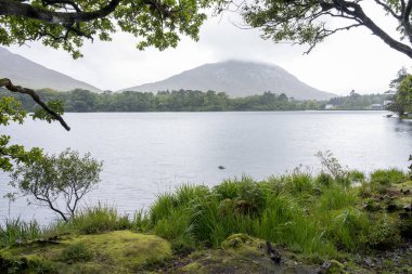 Kylemore Manastırı Gölü: İrlanda 'da bir tepenin eteğindeki gölle çevrili beyaz bir kale / monestery..