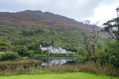 Kylemore Manastırı: İrlanda 'da bir tepenin eteğindeki gölle çevrili beyaz bir şato / manastır.