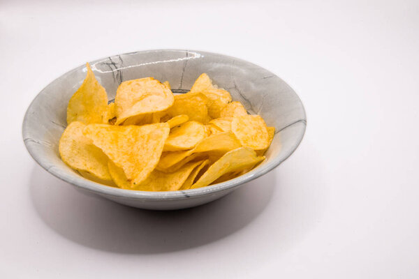 Crisps served in a grey bowl on a plain white background, suitable for snack and food imagery.
