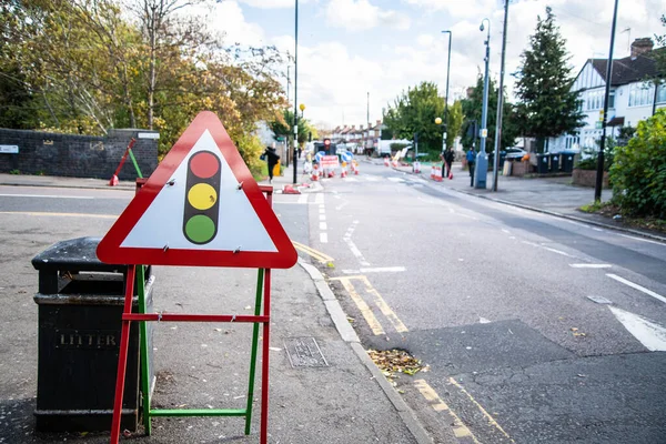 Kırmızı Yol Önündeki Kapalı tabela yaya istikameti işaretinin yanında, İngiltere 'de kapalı bir yol etrafında yaya trafiğine rehberlik ediyor.
