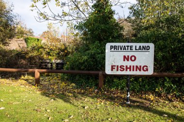 Sarı Beaulieu Özel Mülkiyet Sürücüsü İzinsiz Otopark tabelası yok İngiltere 'de özel erişim kısıtlaması gösteren yapraklı bir yol kenarında.