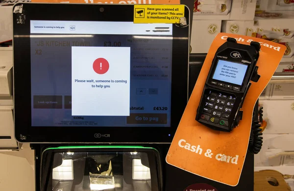 Bir süpermarkette self-servis kontrol ekranı. Lütfen bekleyin. Perakende teknoloji sorunlarını vurgulamak için biri size yardıma geliyor..
