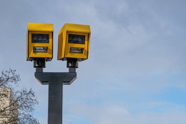İki Gatso hız kamerası bir direğin üzerine monte edilmiş, trafik uygulamasını, yol güvenliğini, hız kontrolünü ve otomatik izleme sistemini temsil ediyor..