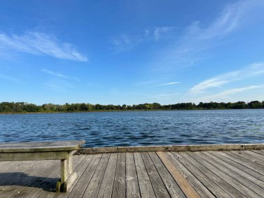 Sakin Mavi Göl kıyısında Bench 'li tahta kaldırım. Yaz Ormanı Manzarası