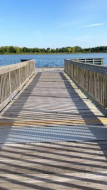 Yavaş kamera, sakin göle ve mavi gökyüzüne doğru ilerler ilkbaharda, Chicago Illinois, dinlendirici rıhtım sakin bahar gölüne yürürken Illinois 'de berrak mavi gökyüzünün altında