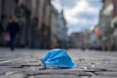 Şehir sokaklarında, Covid-19 salgını sırasında şehir binaları ve telif alanlarıyla düşük açılı koruyucu yüz maskesi atıldı.