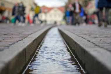 Sokağın asfaltlarında resmi su akıntısı. Almanya 'nın Freiburg şehrindeki ünlü küçük su dolu akarsular.