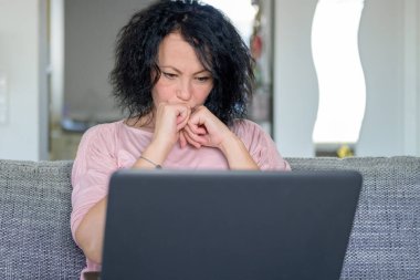 Bilgisayarında çalışan düşünceli bir kadın.