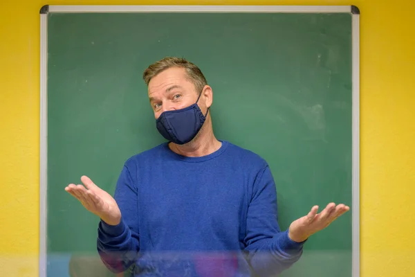 Männlicher Lehrer Mit Gesichtsmaske Gestikuliert Mit Beiden Händen Und Zeigt — Stockfoto