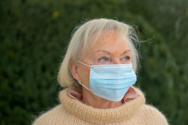 Contemplatieve Senior Vrouw Draagt Een Gezichtsmasker Tijdens Covid Pandemie Als — Stockfoto