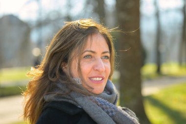 İlkbaharın başlarında parkta bir bankta oturan çekici bir kadın uzak düşünceli bir ifadeyle başını ve omuzlarını dikleştirirken.